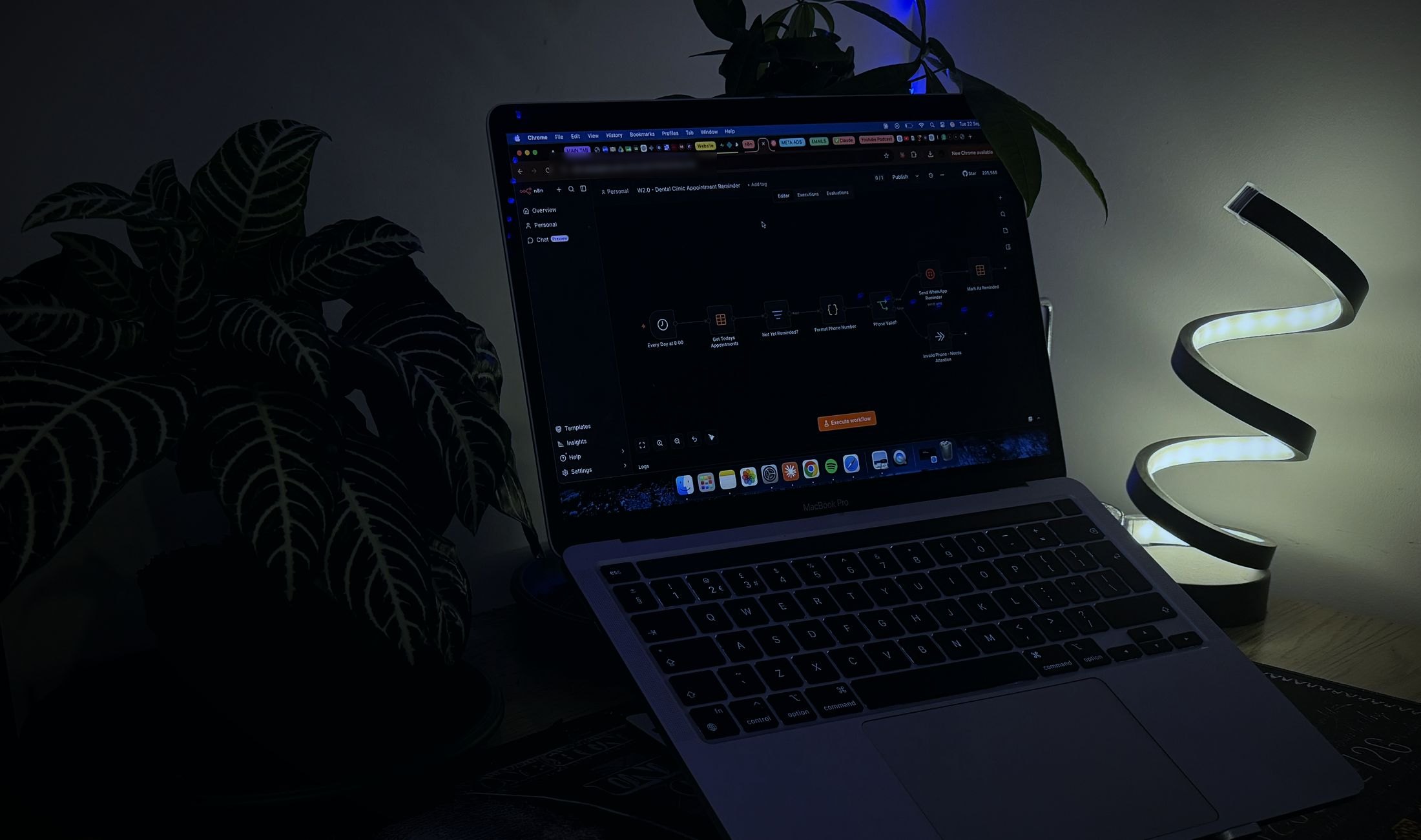 A laptop at night on the Capo Agency desk, with the W2.0 appointment reminder workflow open in n8n.